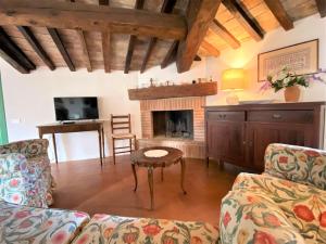 een woonkamer met een bank en een open haard bij La Ginestra - Terrazza in Orciatico