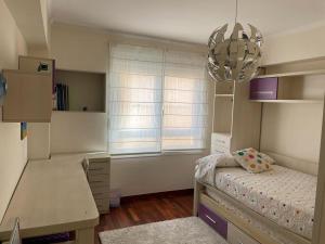 a bedroom with a bed and a desk and a window at Rompeolas in Laxe