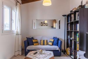 a living room with a blue couch and a book shelf at Ioannis Appartment in Heraklio Town