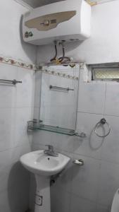 a white bathroom with a sink and a mirror at Nặm Pé Homestay in Bak Kan