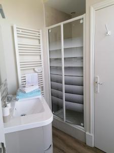 a bathroom with a white sink and a shower at Au Puy Des Vérités in Lapalisse