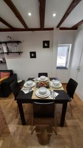 Ad un passo dall'Acquario in zona Expo في جينوا: غرفة طعام مع طاولة مع أطباق وكراسي