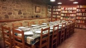 una mesa larga con sillas y platos en una biblioteca en Masia Rovira, en Pinell de Solsonès