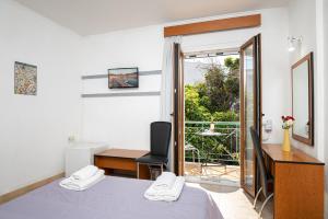 a bedroom with a bed and a desk and a desk at Emily Hotel in Samos