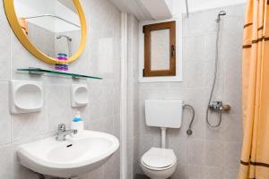 a bathroom with a sink and a toilet and a mirror at Emily Hotel in Samos