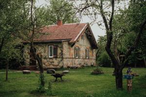 an old stone house in the middle of a yard at Sunny Nights Homestead Historic House in Gataučiai