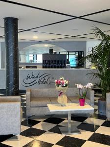 een lobby met een tafel met bloemen erop bij Wind Hotel in Malcesine