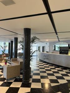 eine Lobby mit schwarz-weiß kariertem Boden in der Unterkunft Wind Hotel in Malcesine