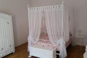 cuna rosa con cortinas blancas en una habitación en Panorama, en Budapest