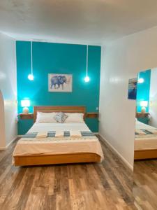 a bedroom with a bed and a blue wall at AVA BEACH HOUSE in Blue Bay