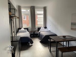 Cette chambre comprend 2 lits, une table et une fenêtre. dans l'établissement Apartment an der Weserpromenade - Schlachte - Parkplätze, à Brême