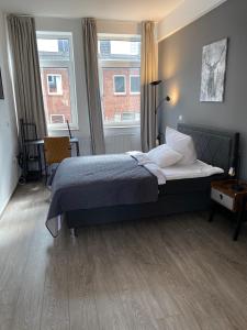 ein Schlafzimmer mit einem Bett und zwei Fenstern in der Unterkunft Apartment an der Weserpromenade - Schlachte - Parkplätze in Bremen