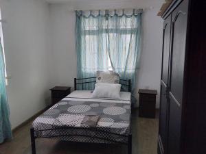 a small bedroom with a bed and a window at Villa Eglantine in Grand Gaube