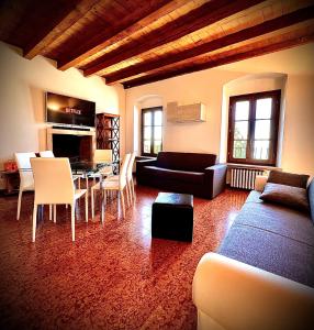 un soggiorno con divano, tavolo e sedie di Welcome Traveller MERLO NERO APARTMENTS a Garda