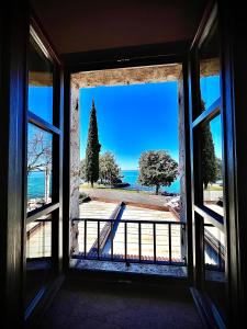 una finestra aperta con vista sull'oceano di Welcome Traveller MERLO NERO APARTMENTS a Garda