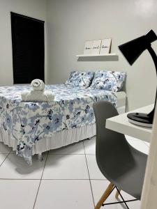 a bedroom with a bed and a desk and a chair at Apartamento em Boa Vista in Boa Vista