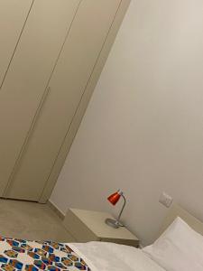 L'angolo di Costalpino في سيينا: غرفة نوم مع سرير ومصباح على كومودينو