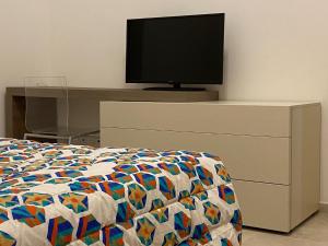 L'angolo di Costalpino في سيينا: غرفة نوم مع سرير وتلفزيون في خزانة