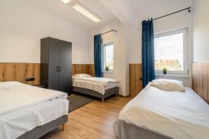 1 dormitorio con 2 camas y ventana en Gems Hostel, en Glogovia