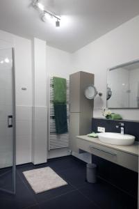 a white bathroom with a sink and a mirror at Ferienwohnung Kerst in Schweigen-Rechtenbach