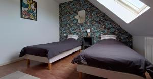 a bedroom with two beds and a wall at Maison de vacances bord de mer Sibiril Moguériec finistère la villa Léonie in Sibiril