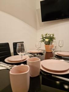 a table with plates and wine glasses on it at Apartman Sandro in Motovun