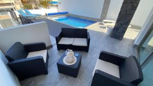 an aerial view of a patio with chairs and a pool at Super cool villa in Los Cristianos in Los Cristianos