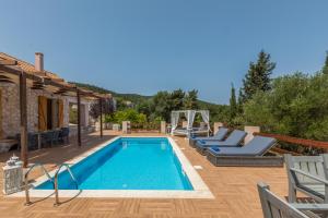 a pool with lounge chairs next to a house at Villa Celeste in Evretí