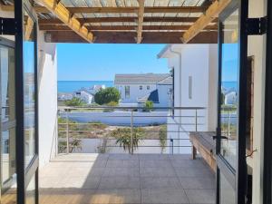 a balcony with a bench and a view of the ocean at The Starling in St Helena Bay