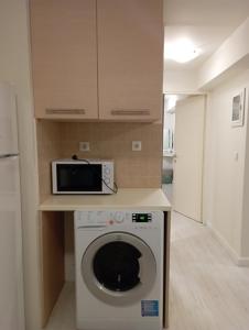 a kitchen with a washing machine and a microwave at Piccolo Centrale in Corfu
