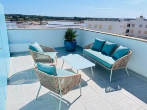 a patio with chairs and a table on a balcony at Blue House Mallorca in Ses Salines