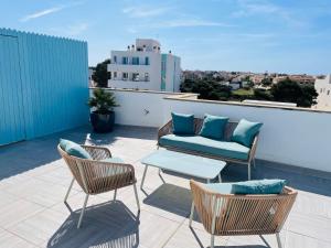 a patio with chairs and a couch on a roof at Blue House Mallorca in Ses Salines