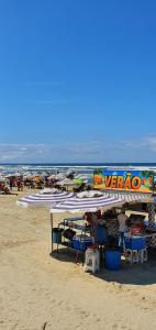 a veraza tent on a sandy beach with the ocean at Apartamento na Praia in Praia Grande