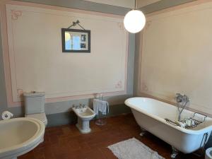 ein Badezimmer mit einer Badewanne, einem WC und einem Waschbecken in der Unterkunft House on the river in Calci