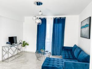 niebieską kanapę w salonie z niebieskimi zasłonami w obiekcie BLUE LATSI w mieście Latsi