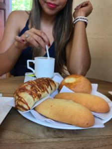 a woman sitting at a table with a plate of bread at Casa Sua in Barichara
