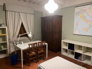 um quarto com uma secretária e uma mesa com cadeiras em House on the river em Calci