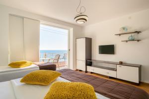 1 dormitorio con 2 camas, TV y balcón en Apartments Banje Beach, en Dubrovnik