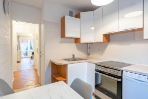 Karkonosky Apartamenty - Ismena في شكلارسكا بوريبا: مطبخ بخزائن بيضاء ومغسلة