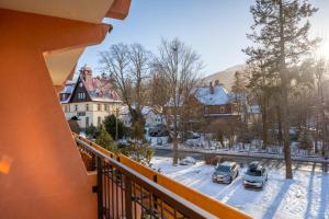 Karkonosky Apartamenty - Ismena في شكلارسكا بوريبا: شرفة مطلة على ساحة مغطاة بالثلج