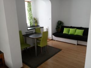 ギジツコにあるGiżycko Studio Apartamentのリビングルーム(テーブル、緑の椅子付)