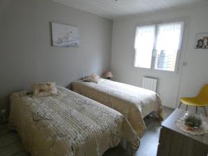 een slaapkamer met 2 bedden en een raam bij L'ESCALE Côte d'Opale in Hesdigneul-lès-Boulogne