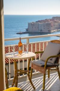 una botella de vino y copas en una mesa del balcón en Apartments Banje Beach, en Dubrovnik