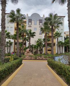 a building with palm trees in front of it at Aldea del Mar in Torrevieja