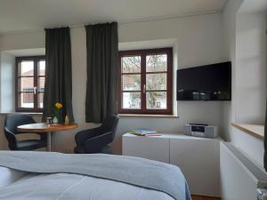 a hotel room with a bed and a tv at Tiny X im Marxhof Seebruck am Chiemsee in Seebruck