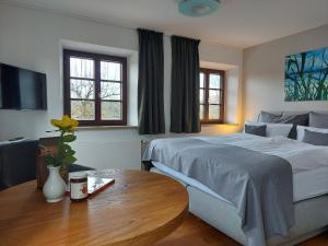 a bedroom with a bed and a table and a tv at Tiny X im Marxhof Seebruck am Chiemsee in Seebruck