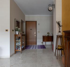 einen Flur mit Tür und Uhr an der Wand in der Unterkunft Nonna Mary's Apartment - Vicino Pala Alpitour in Turin