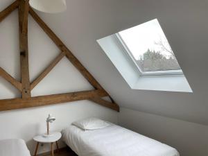una camera mansardata con letto e finestra di GÎTE 2 Ferme de la Haute Escalles a Escalles