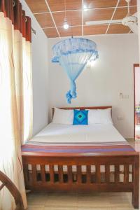 een slaapkamer met een bed met een paraplu op de muur bij Lakeside Villa in Anuradhapura