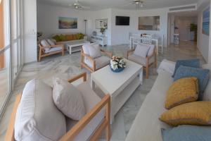 ein Wohnzimmer mit Sofas und Stühlen sowie ein Wohnzimmer in der Unterkunft Apartamentos Las Americas in Islantilla